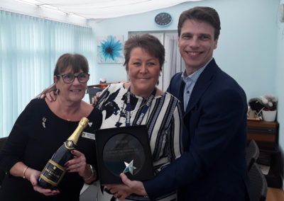 Gill Redsell (Meyer House Manager, Viv Stead (Recreation & Well-Being Manager), Martin Barrett (Managing Director) posing with the Champion Fundraising trophy and champagne