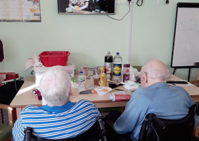 Two gentlemen residents sitting together watching comedy on TV