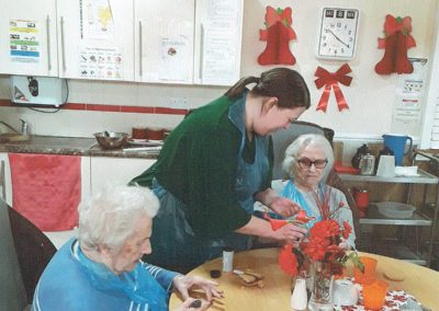 Two female residents at Meyer House Care Home getting creative in the dining area