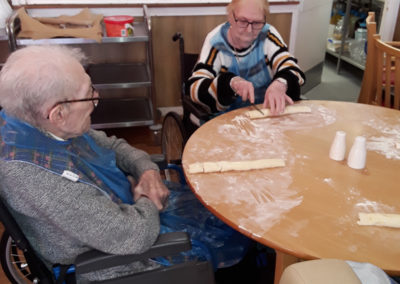 Male residents sat at a table making sausage rolls