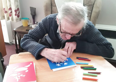 A resident making a Christmas card with stencils