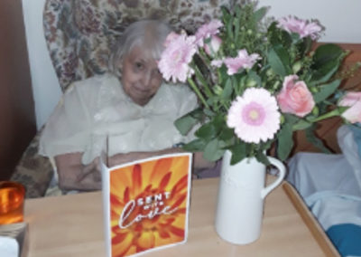 Meyer House resident Kath with flowers and card from her family