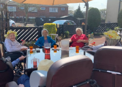 Meyer House residents enjoying a refreshing drink in the sunny front garden