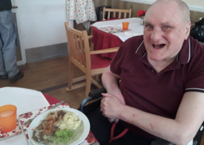 Meyer House Care Home resident smiling about to eat his lunch