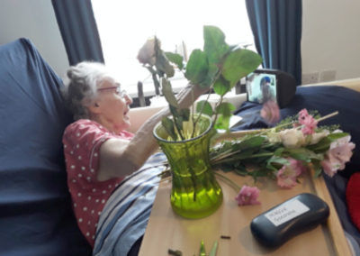 Resident flower arranging and video calling her daughter