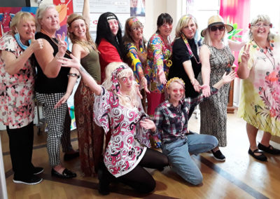 Staff team posing in sixties fancy dress at Meyer House Care Home