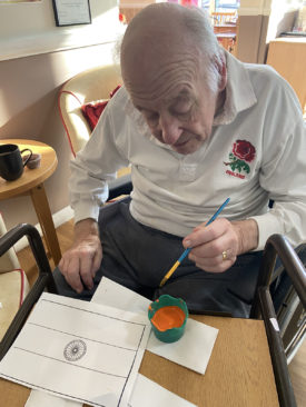 Gentleman painting an Indian flag at Meyer House Care Home