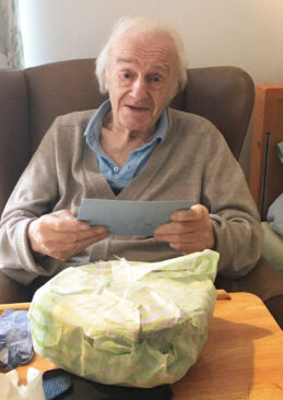 Meyer House Care Home resident with a birthday card and present